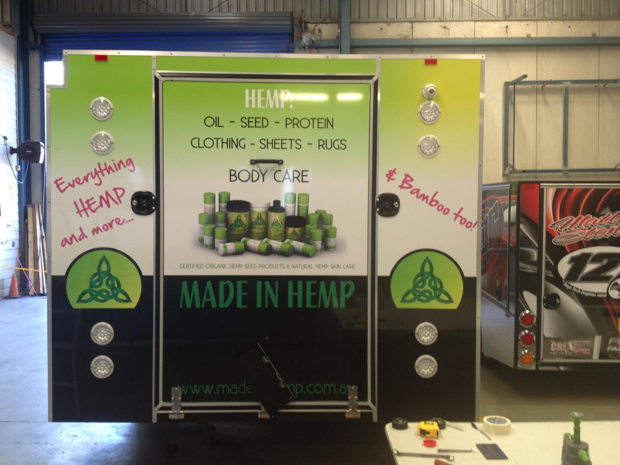 Rear view of the custom Made In Hemp market trailer with hemp oil, seed, protein, clothing, sheets, rugs and body care signage